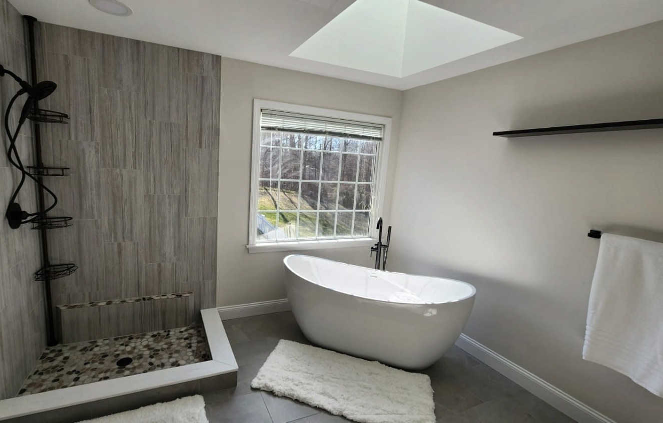 Master bath remodel with freestanding tub, custom pebble-floor tile shower, and skylight